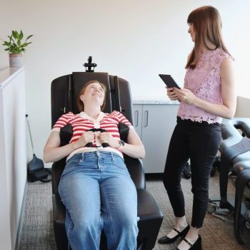 Patient receiving spinal decompression therapy while clinician monitors treatment settings.